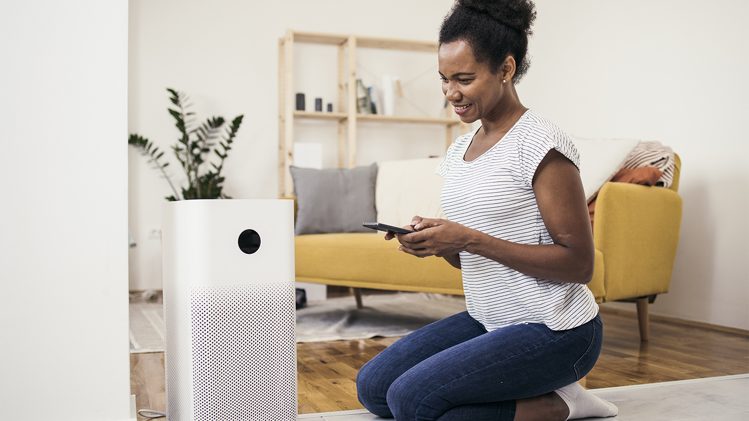 woman adjusting air purifier at home